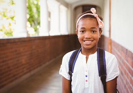Somesa education plan young girl with her backpack standing in the school hall